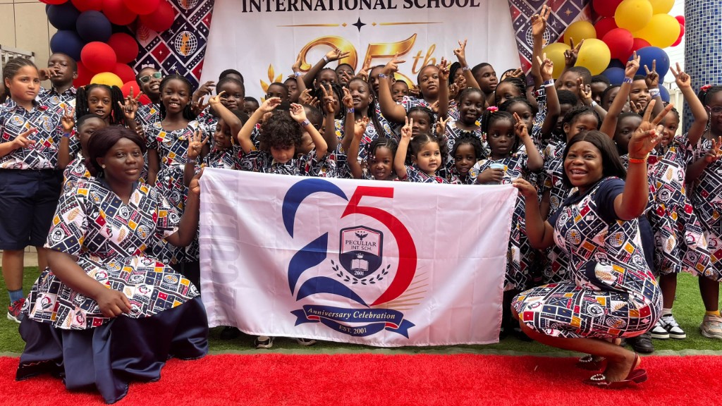 Students and staff celebrating the 25th anniversary with the anniversary banner